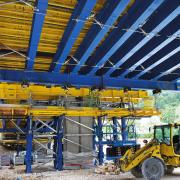 Bei der Koppelfuge wurde das Traggerüst einseitig an den bereits bestehenden Betonierabschnitt aufgehängt. Die erforderlichen Anpressdrücke für die Hydraulikzylinder wurden präzise berechnet. Copyright: Doka