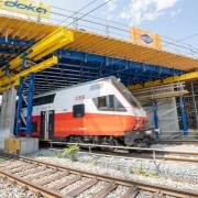 Bahn-Baustelle mit Doka UniKit, ÖBB-Zug durchquert Brückenbaustelle.