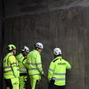 construction workers discussing in front of concrete wall